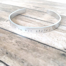 Load image into Gallery viewer, I am not alone hand stamped affirmation bangle bracelet